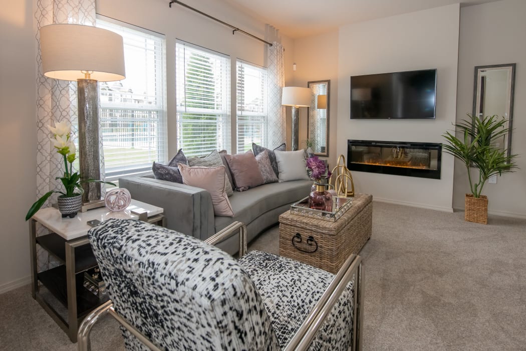 Bright, inviting living room with LED fireplace at Bend at New Road Apartments in Waco, Texas