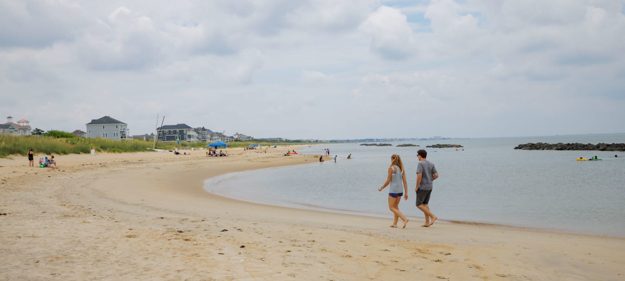 Residents walking on the beach near Village Square Apartments in Norfolk, Virginia