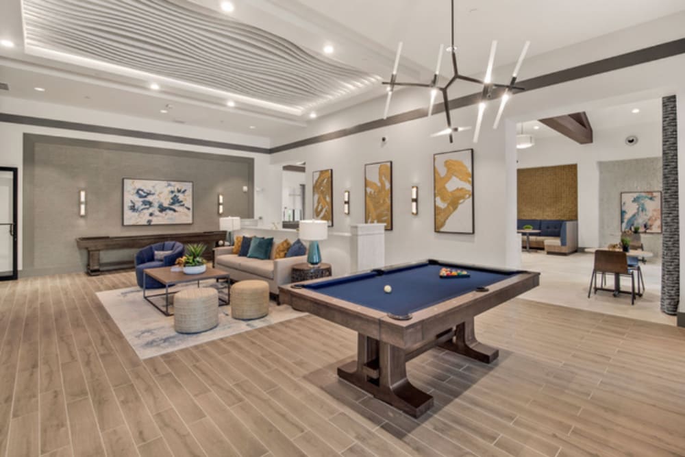 Modern and sleek clubhouse interior with pool table at Murano at Three Oaks in Fort Myers, Florida