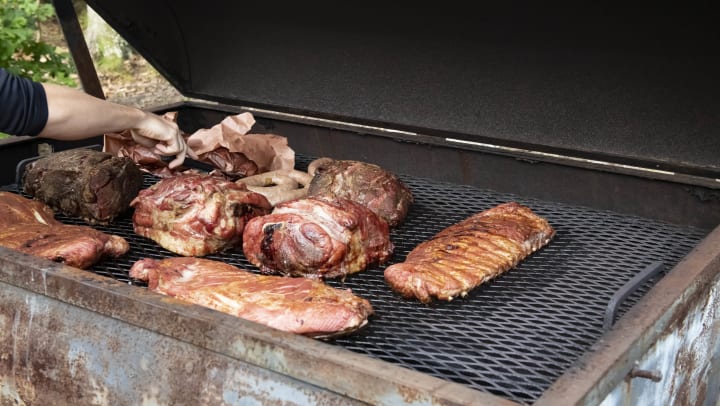 Someone flipping various cuts of meat on a grill | BBQ joints around Midland