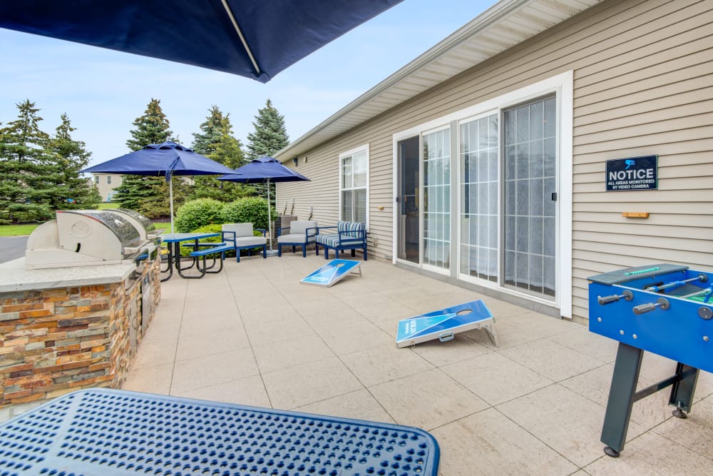 Grilling stations and outdoor games by the swimming pool at Avon Commons in Avon, New York