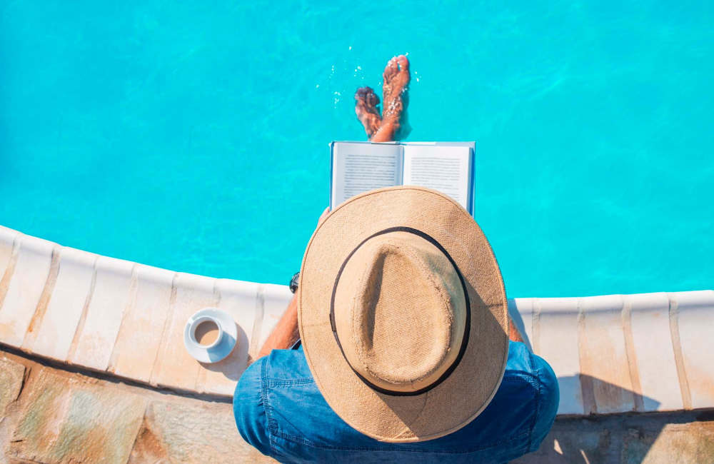 Resident relaxing on the edge of a swimming pool at Hillside Apartments in Laredo, Texas