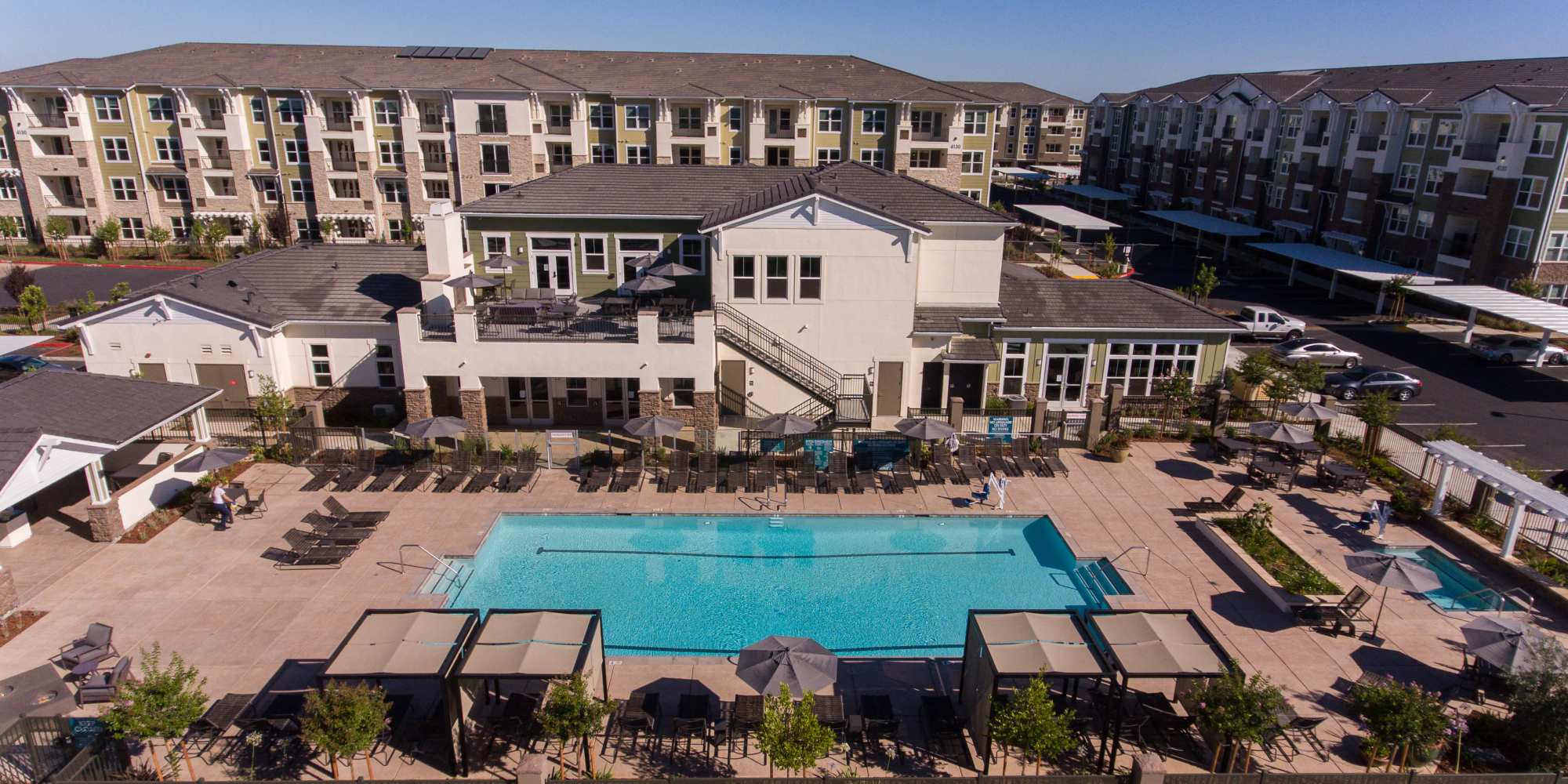 Aerial view of the swimming pool and building at Alira Apartments in Sacramento, California