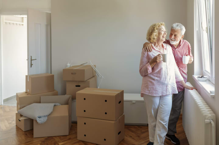 Senior couple in empty room with boxes