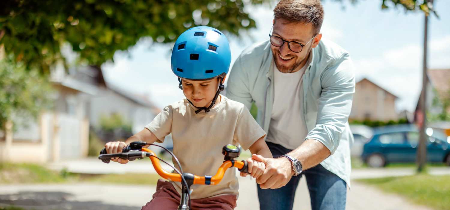Resident teaching his son how to ride near Amberly Trace Apartments in Burlington, North Carolina