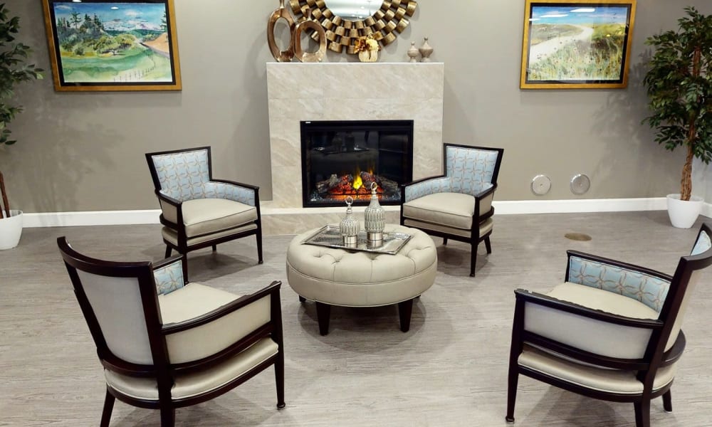 Four chairs near a fireplace at Keystone Place at Bonita Springs in Bonita Springs, Florida
