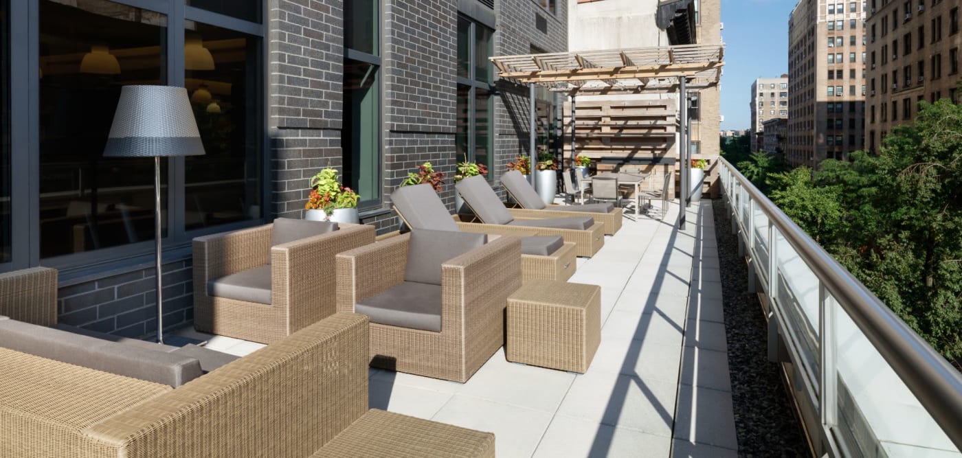 Outdoor lounge area with comfy chairs and couches at The Melar in New York, New York