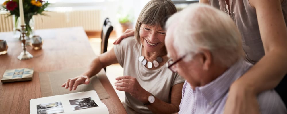 Two residents looking through a photo album at Waverly Place in Albany, Oregon