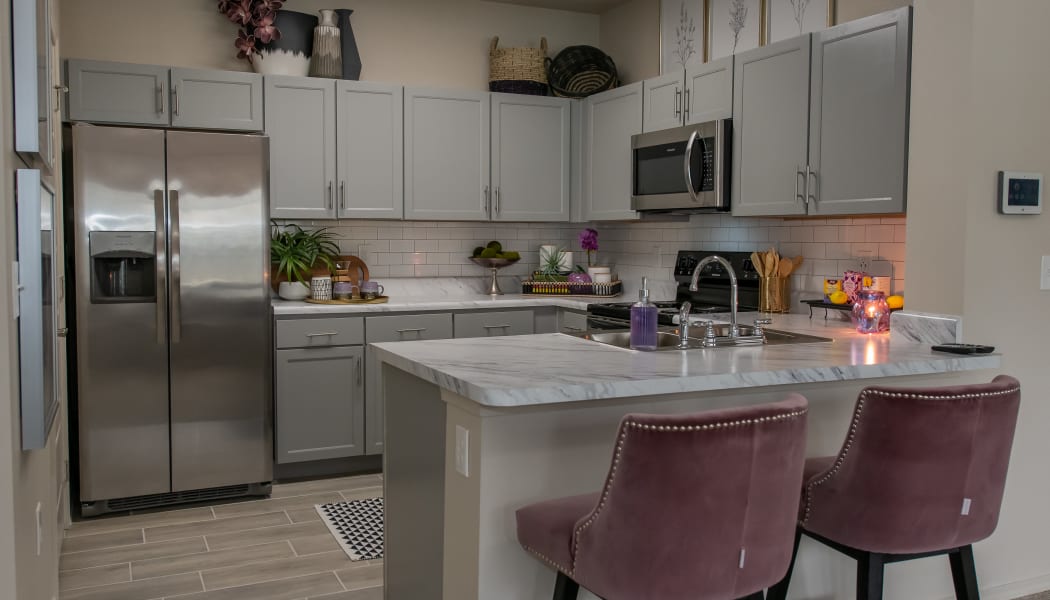 Modern kitchen with granite counters at Bend at New Road Apartments in Waco, Texas