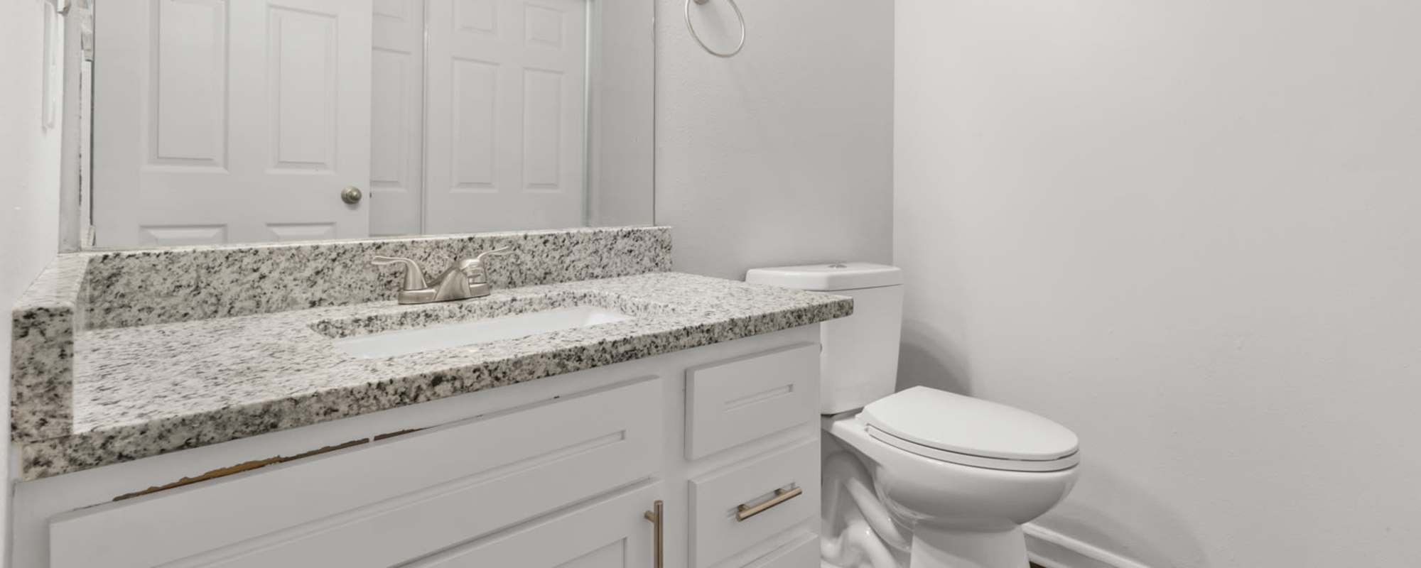Well lit bathroom with cabinet, sink, and toilet at Eagle's Edge in Indianapolis 