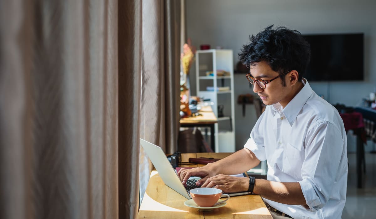 A resident using his laptop in his apartment at Regency Apartments in Lawton, Oklahoma