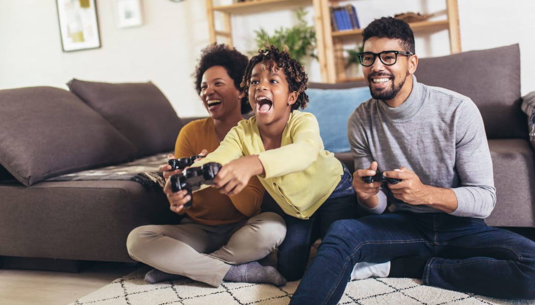 A family playing video games at Turtle Creek Vista Apartments in San Antonio, Texas