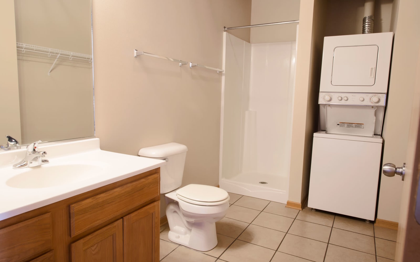 Studio apartment bathroom with a stacked washer and dryer at West Towne in Ames, Iowa