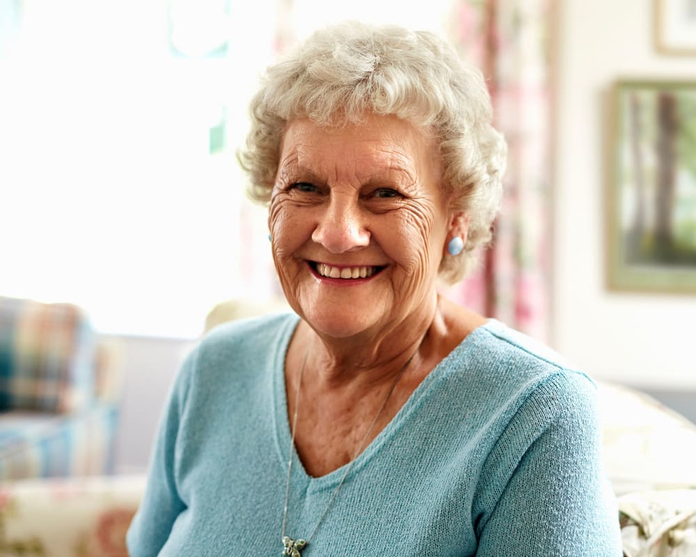 A smiling resident at Chateau Gardens Memory Care in Springfield, Oregon