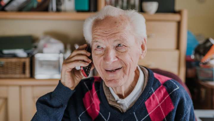 Elderly man smiling and on the phone. 