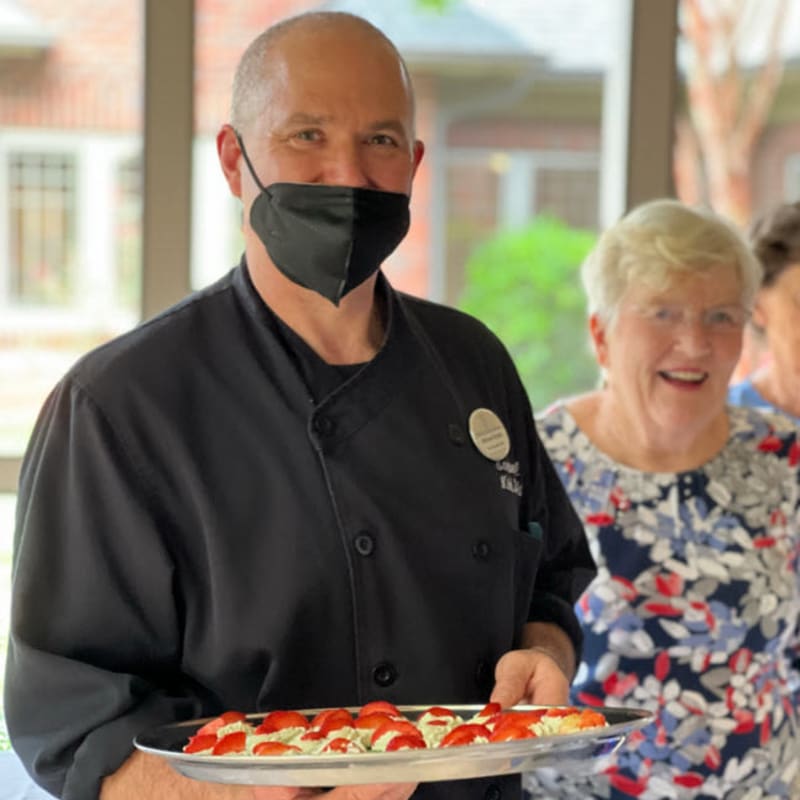 Chef and resident with appetizer tray at The Foothills Retirement Community in Easley, South Carolina