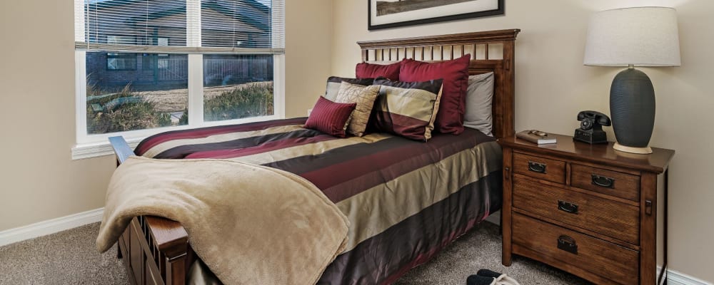 Rustic upscale senior living bedroom with wood accents at The Springs at Grand Park in Billings, Montana