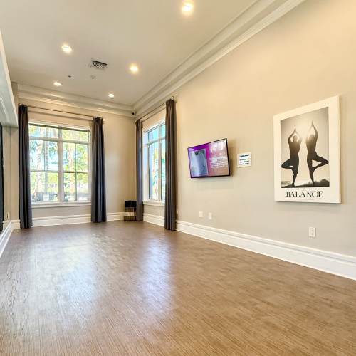 Community empty room with television at {location_name}} in Plantation, Florida