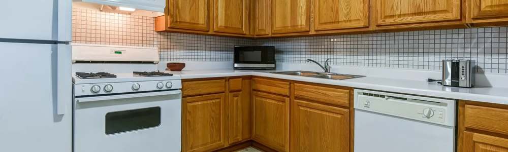 Fully equipped kitchen with granite countertops stainless steel appliances like a refrigerator, stove, and drawer microwave at Park Ridge Commons in Des Plaines, Illinois