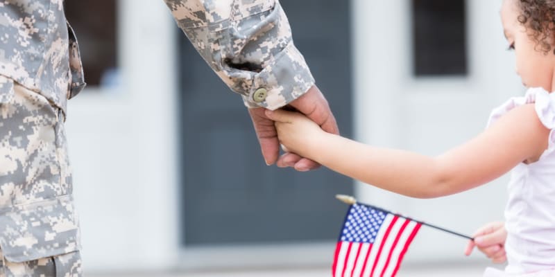 A military father holding his daughter's hand at Joshua Heights in Twentynine Palms, California