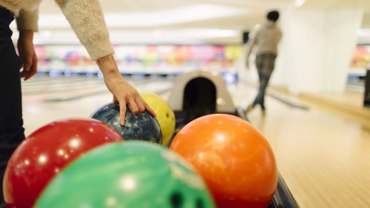 Brightly colored bowling balls lined up in the ball return