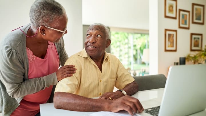 Elderly couple using lap top