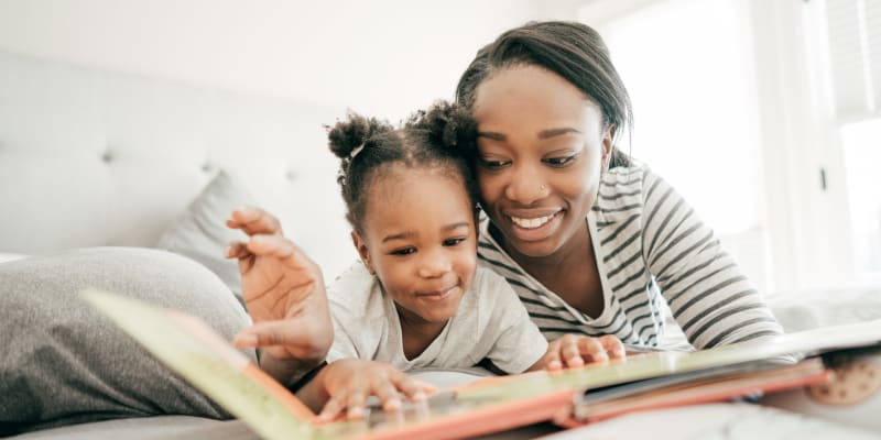 A mother reading a book with her daughter in a home at Eagleview in Joint Base Lewis McChord, Washington