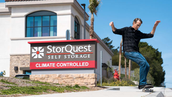 Tony Hawk in front of a StorQuest sign