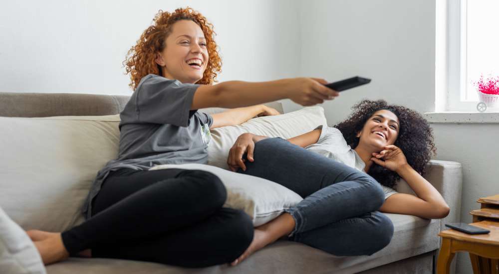 Happy residents relaxing and watching the TV at Towne East Village Apartment Homes in Converse, Texas 