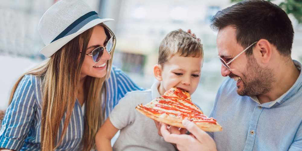 Resident family having pizza near Stadium Loft Apartments in Saint Louis, Missouri
