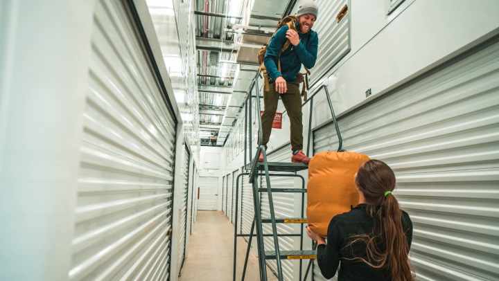 Two storage users assisting one another with heavy items