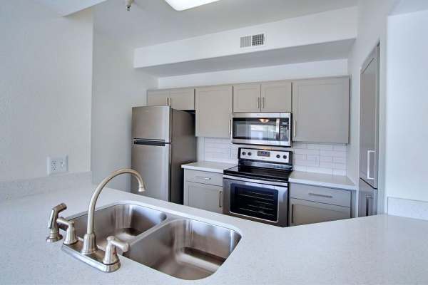 Kitchen with stainless-steel appliances and quartz countertop at San Marino in Tempe, Arizona