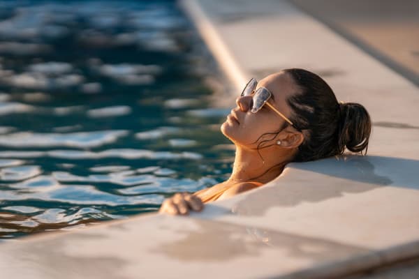 A resident relaxes in the outdoor swimming pool at Marina Breeze in San Leandro, California