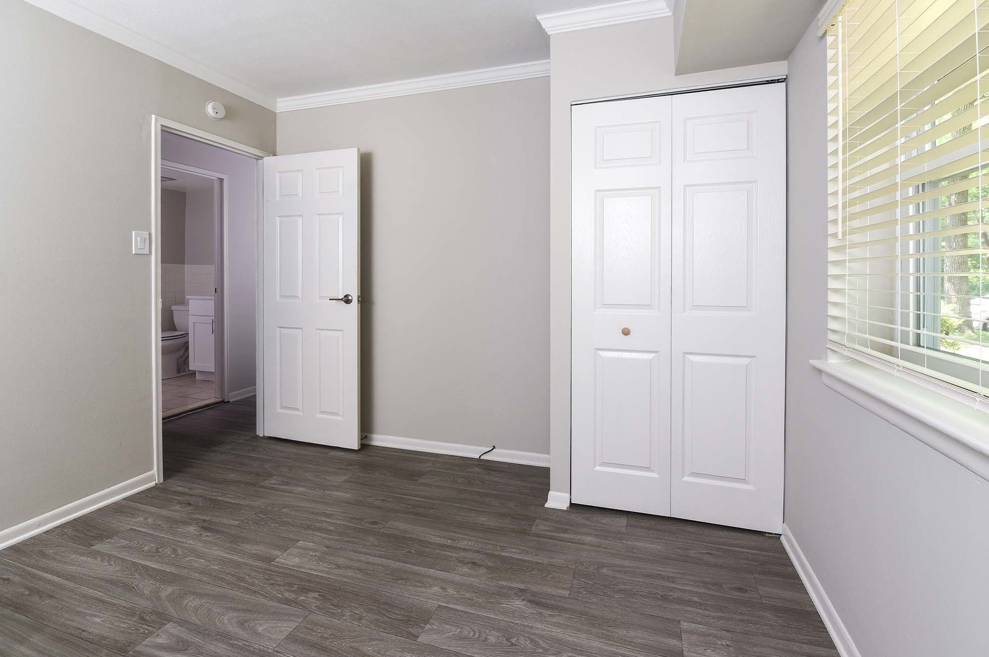 empty bedroom with gray walls dark hardwood like plank flooring at The Nolan, Morrisville, Pennsylvania
