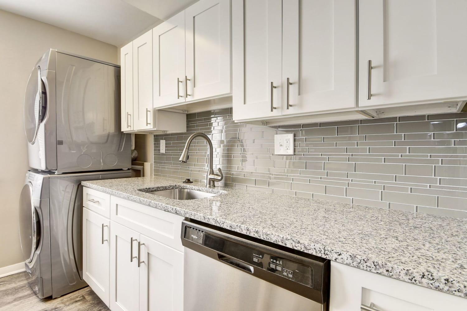 Kitchen with white cabinets, granite countertops, and stainless steel appliances