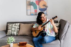 Resident playing guitar in her living room at Seaglass Cottage in North Myrtle Beach, South Carolina