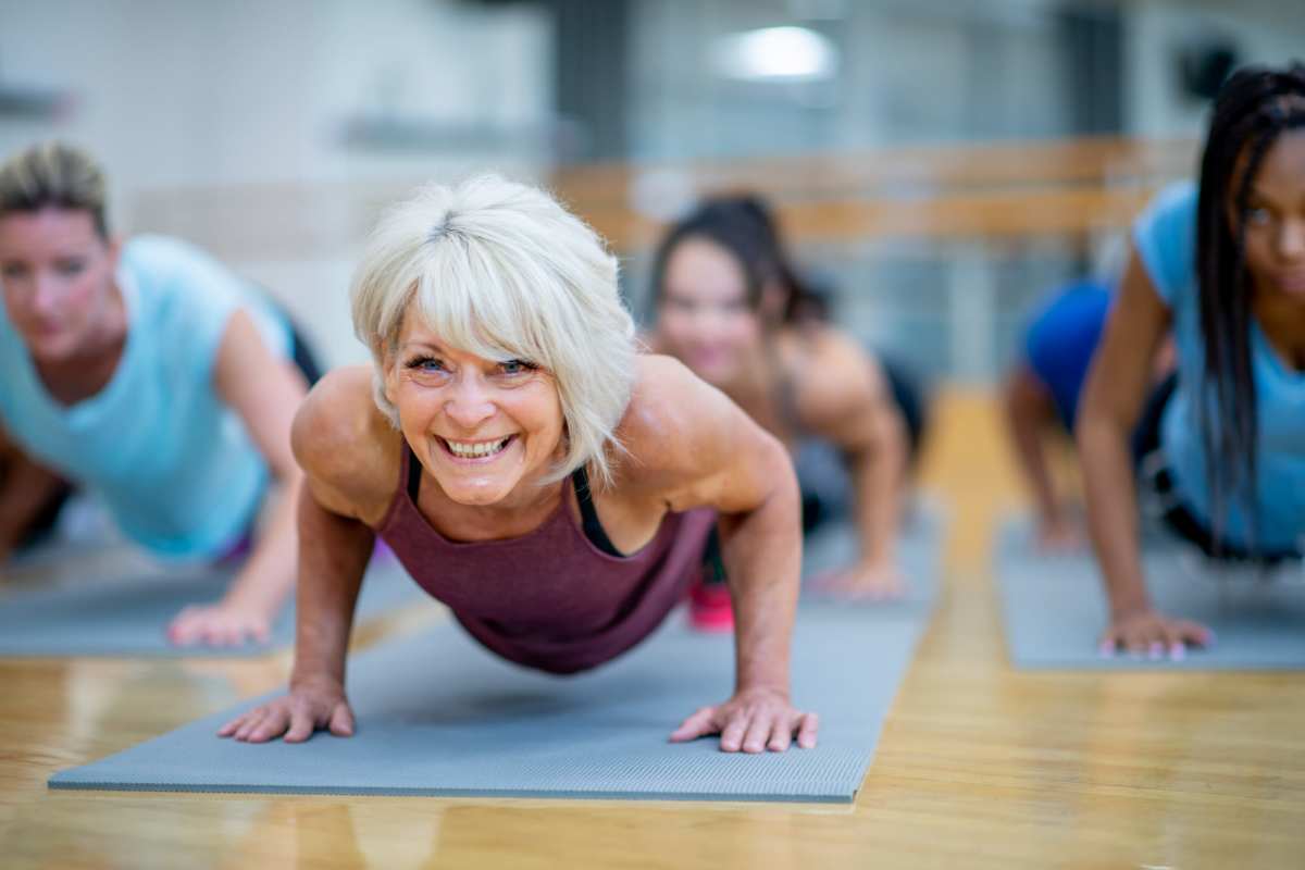 Group workout session with women performing push-ups on mats at Villas At Alexander Bay in Baytown, Texas