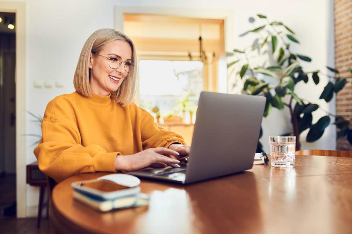 Woman working on laptop at dining table at The Towns at Patuxent Overlook in Lexington Park, Maryland 
