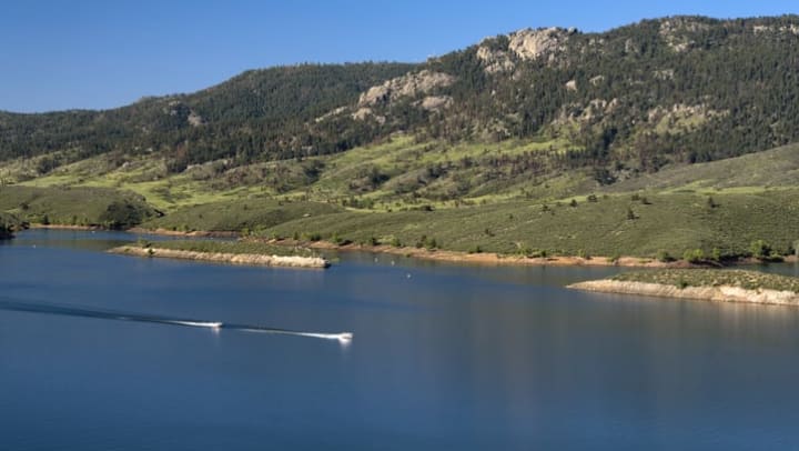 Boaters zoom across Horsetooth Reservoir near {{location name}} in Fort Collins, CO.