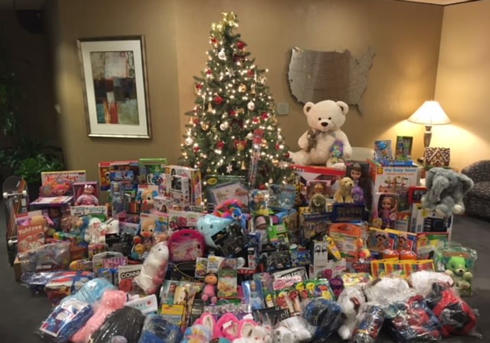 Hundreds of presents under the Christmas tree about to go to families in need from American Capital Group in Bellevue, Washington