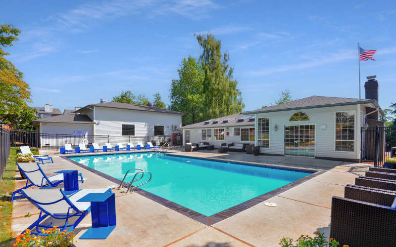 Seating near the swimming pool on a sunny day at Wellington Apartments in Silverdale, Washington