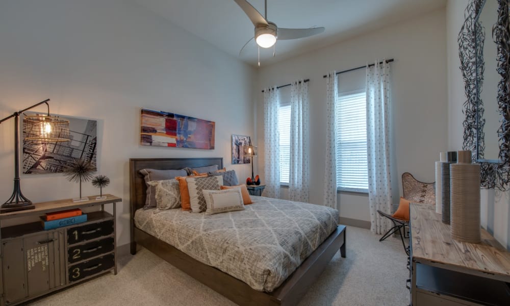 Decorated bedroom with ceiling fan and carpet at Bellrock Upper North in Haltom City, Texas