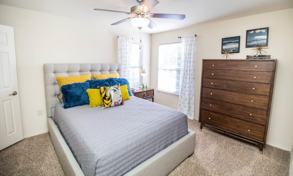 Bright bedroom with tall windows at Tuscany Place in Lubbock, Texas.