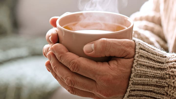 senior woman keeping warm with hot drink