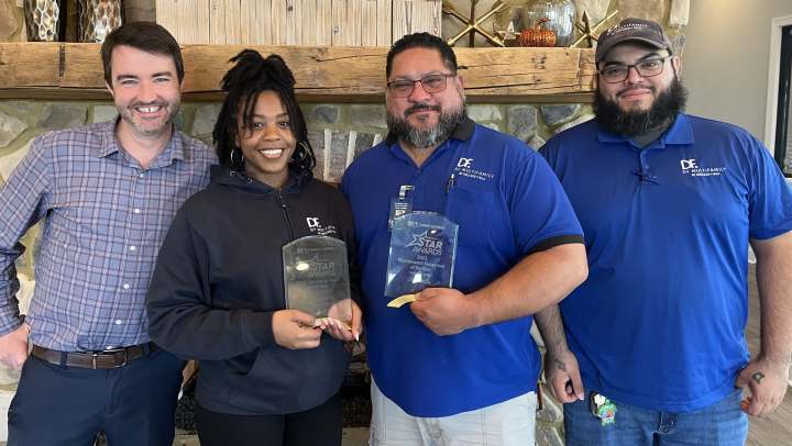 People posing together with their awards at