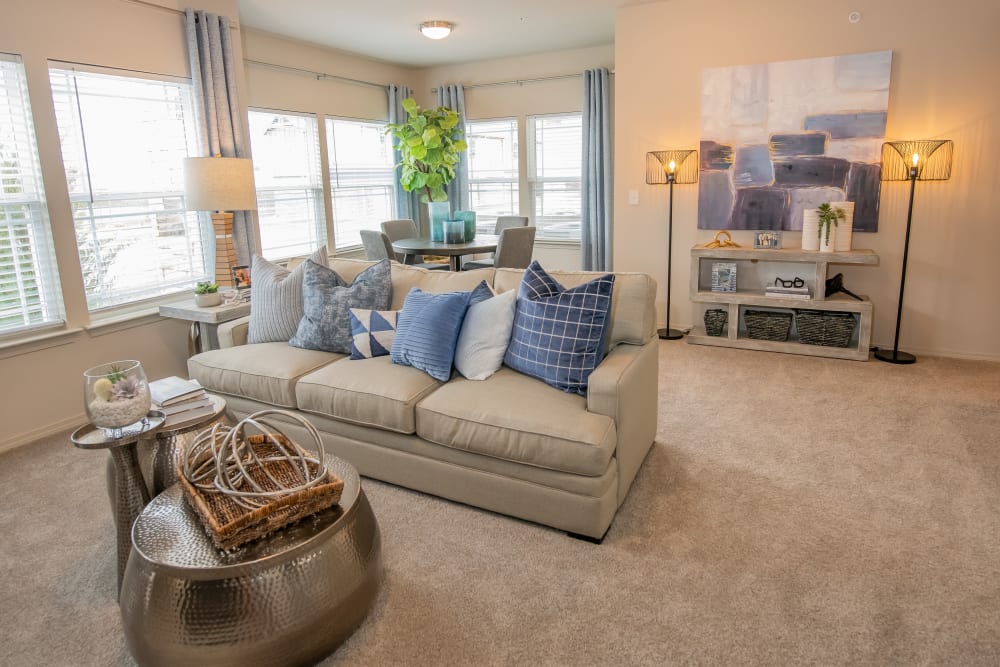 Bright living room with plush carpet at Bend at New Road Apartments in Waco, Texas