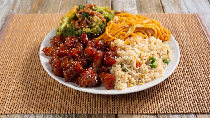 A plate of Chinese food with fried rice, broccoli, and more