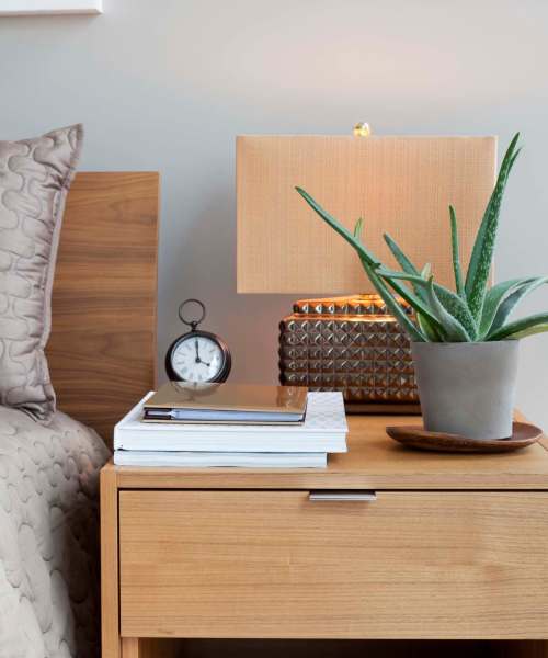 Nightstand next to a bed at Ventura Park Plaza Apartments in Portland, Oregon