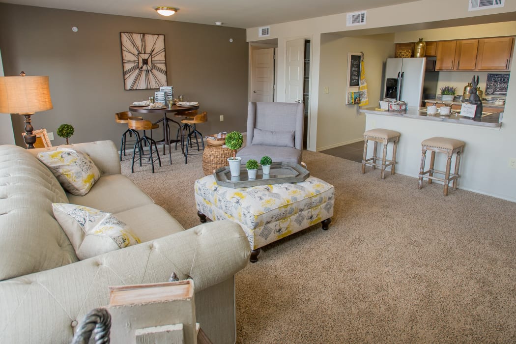 Living room with a view of the kitchen at Icon at Norman in Norman, Oklahoma
