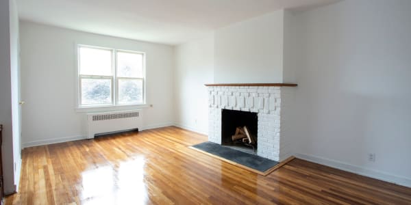 Unfurnished home with a fireplace and nice wood style flooring at Eastgold Westchester in Dobbs Ferry, New York
